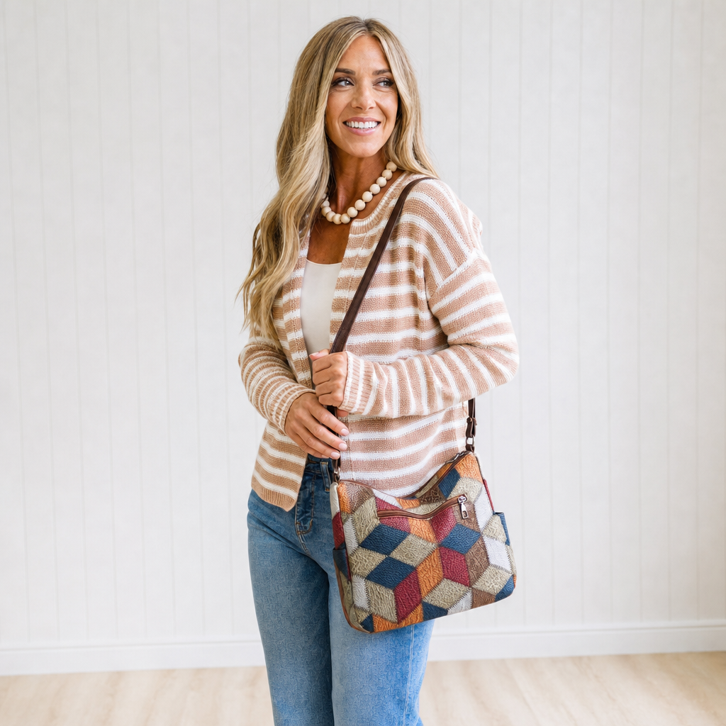 Nella patchwork shoulder bag worn over the shoulder with jeans and a striped cardigan