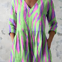 Green long blouse with V-neck worn loose over trousers