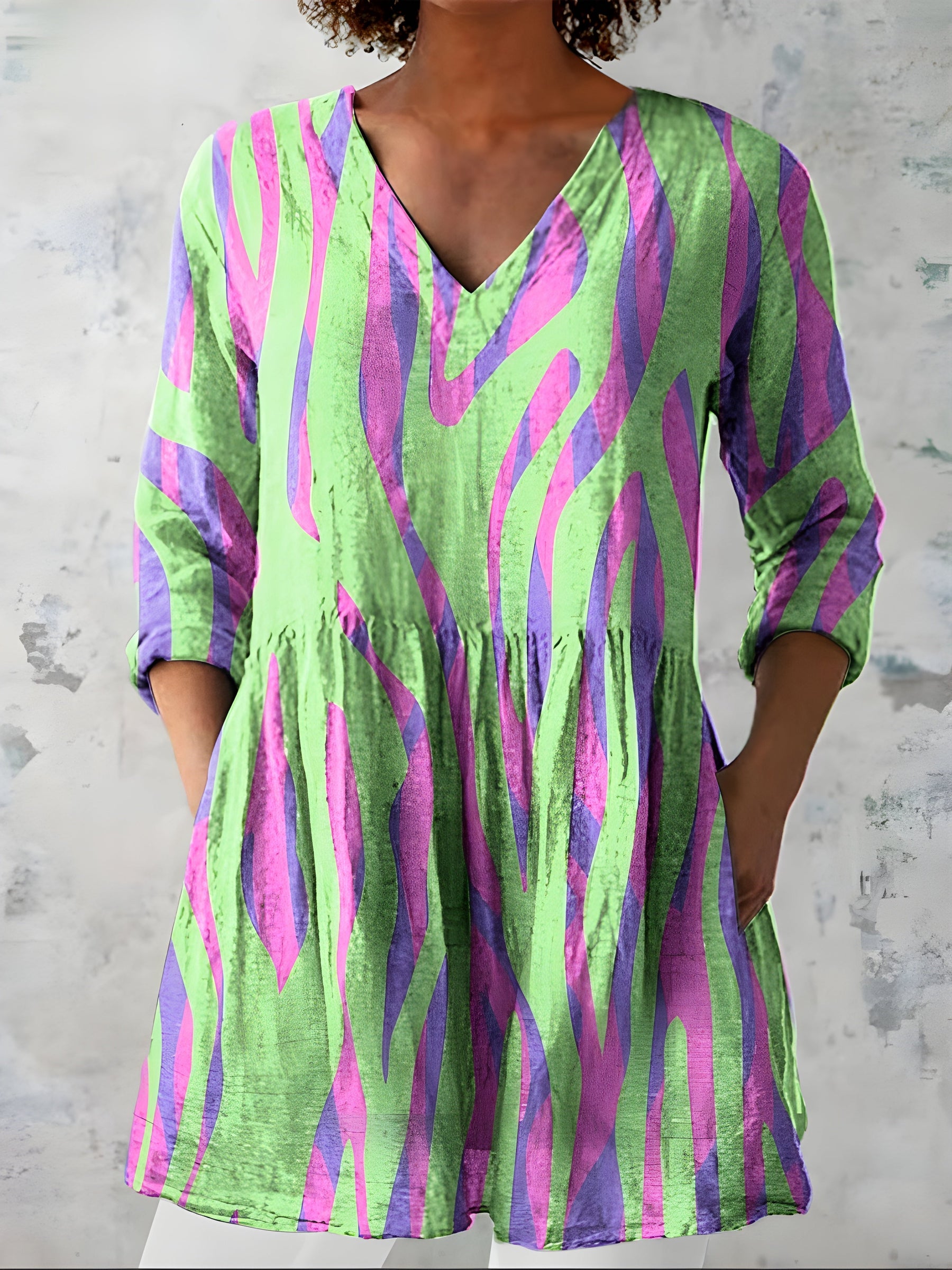 Green long blouse with V-neck worn loose over trousers
