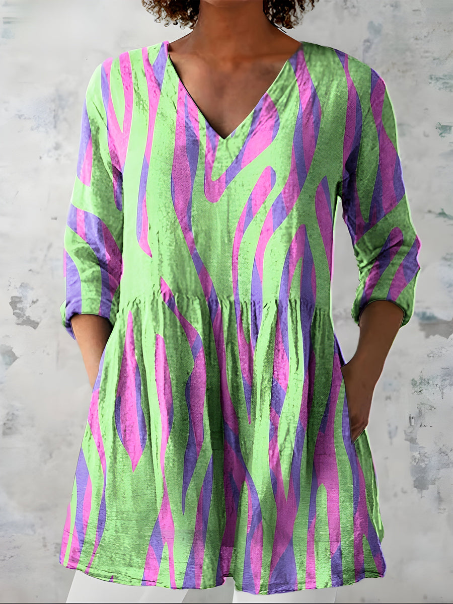 Green long blouse with V-neck worn loose over trousers