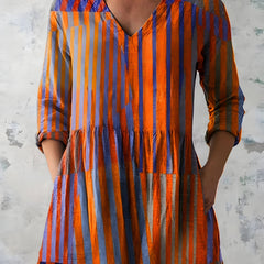 Orange long blouse with V-neck styled on model