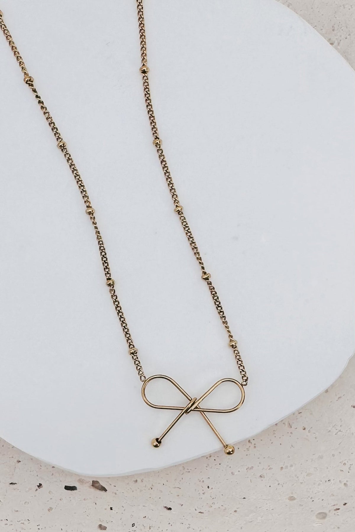 Ivy Dainty Bow Necklace in gold, bow charm detail